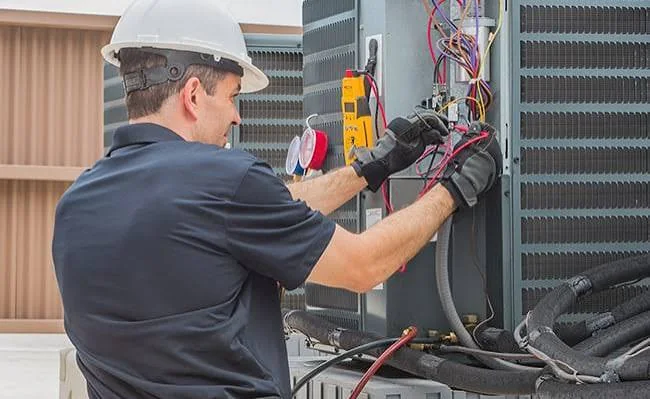 Technician wiring a residential outdoor air conditioning system
