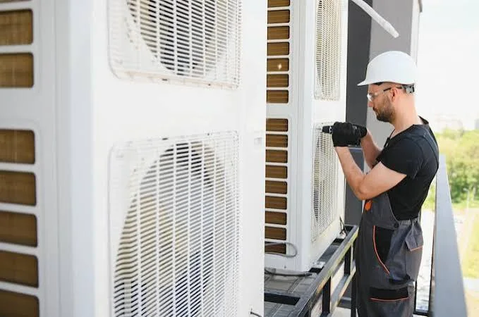 Technician inspecting ventilation equipment for reliable indoor airflow