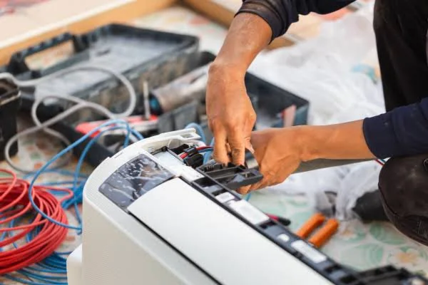 Technician testing electrical controls on a home comfort system